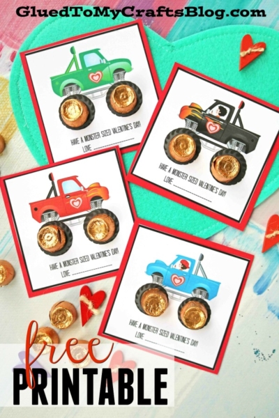 Four colorful monster truck valentines with chocolate candy wheels, each reading “Have a monster sized Valentine’s Day! Love,” displayed on a light background with craft supplies. Perfect for any monster truck valentine card exchange!.