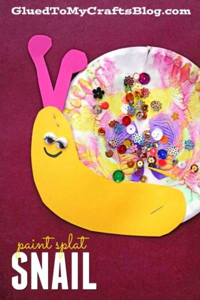 A colorful paint splat snails craft made from a painted paper plate, yellow paper, pink paper for antennae, and decorated with sequins and beads. Text reads paint splat snail.