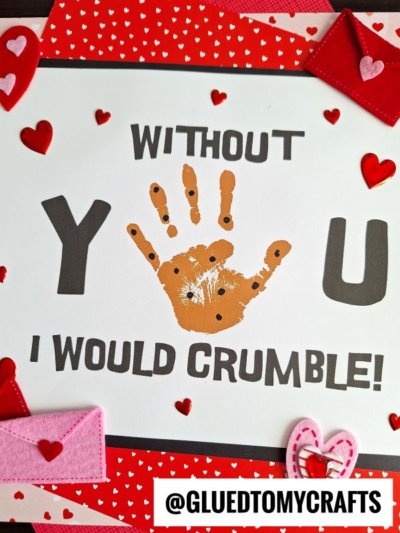 A handmade Valentine’s card with red and pink hearts, felt envelopes, and the message “Without you I would crumble!” The brown handprint “O” in “YOU” makes it a perfect mother’s day keepsake. @GLUETOMYCRAFTS at the bottom.