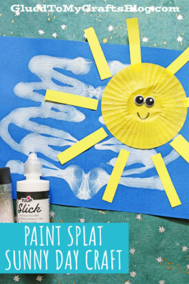 A sunshine craft for kids: a yellow paper cupcake liner sun with paper rays, googly eyes, and a smile on blue paper. White paint and glitter add sparkle, while paint splat clouds complete this sunny day kid craft scene.