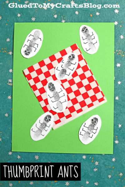 A craft featuring thumbprint ants on white ovals, arranged around a red-and-white checkered picnic blanket atop a green paper background with small white stars. Text reads Thumbprint Ants.