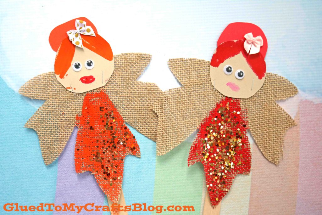 Two enchanting leaf fairy puppets crafted from wood sticks, burlap wings, glittery red dresses, and paper hats with bows, displayed on a pastel background.