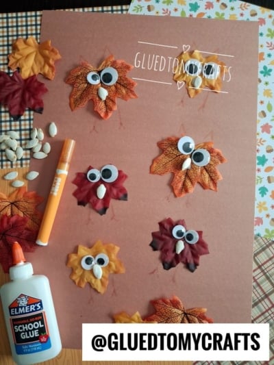 A brown sheet displays leaf owls with googly eyes, marker-drawn beaks, and pumpkin seed wings—perfect for anyone searching for creative leaf kid craft ideas. Craft supplies, glue, and a marker are nearby. @GLUEDTOMYCRAFTS is written at the bottom.