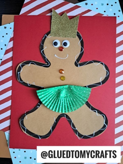 A gingerbread princess made from brown paper with a gold crown, googly eyes, buttons, and a green cupcake liner skirt, displayed on red and striped backgrounds. @GLUEDTOMYCRAFTS text is at the bottom.