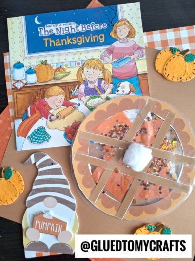 Children’s Thanksgiving book with pie craft, stained glass pie activity, felt pumpkin and gnome decorations, and autumn-colored paper on a table. The book cover shows children preparing food. A tag reads @GLUEDTOMYCRAFTS.