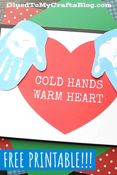 A craft featuring a large red heart with the phrase cold hands warm heart and two blue handprints on either side, plus FREE PRINTABLE!!! written below. Blog name is displayed at the top.