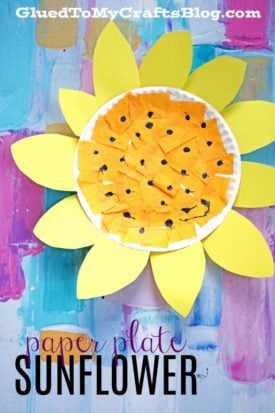 A bright paper plate sunflower craft made with yellow tissue paper and paper petals, shown on a vibrant painted background. Text at the bottom reads "paper plate SUNFLOWER.