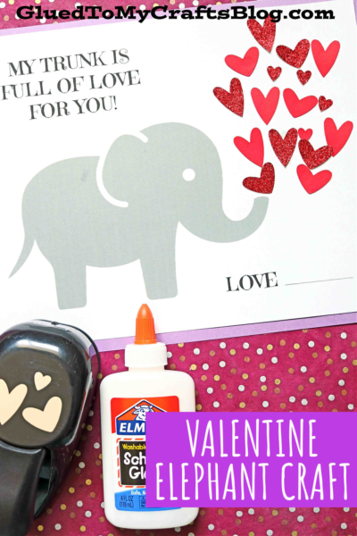 A gray elephant with an elephant trunk full of love sends red heart shapes from its trunk, printed on paper that says, MY TRUNK IS FULL OF LOVE FOR YOU! Supplies like a heart punch, glue, and hearts are shown. Text: VALENTINE ELEPHANT CRAFT.