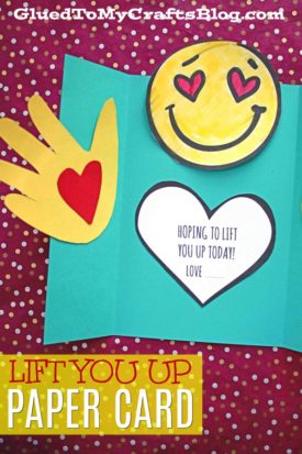 An open handmade lift you up card with a yellow hand cutout, a heart, and a smiling face with heart eyes. Inside, the message reads, “Hoping to lift you up today! Love.” The red background features cheerful white polka dots.
