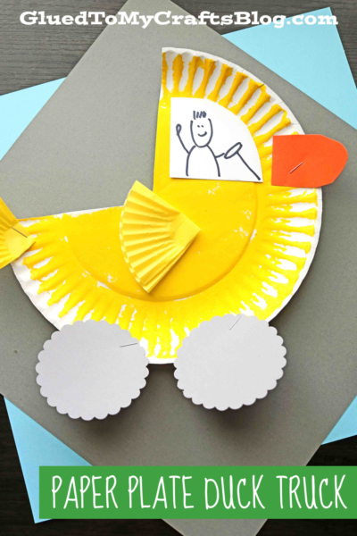 A cute paper plate duck truck craft features a yellow painted plate as the truck body, cupcake liners for wings, gray paper wheels, and “Paper Plate Duck Truck” text on colorful paper underneath.