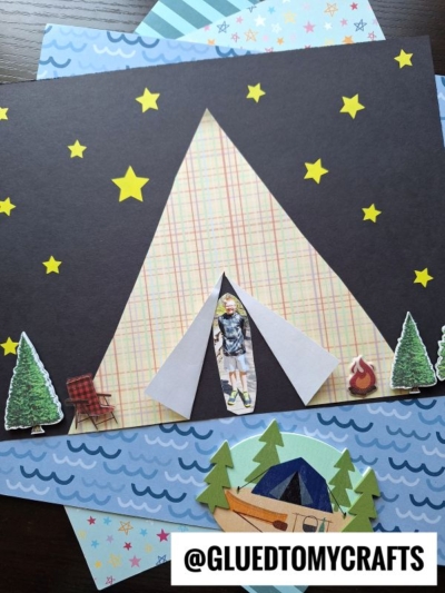 A handmade paper tent kid craft features a tent made from patterned paper, surrounded by star stickers, paper trees, a chair, a campfire, and a cutout of a child. The background includes layered blue and patterned papers.