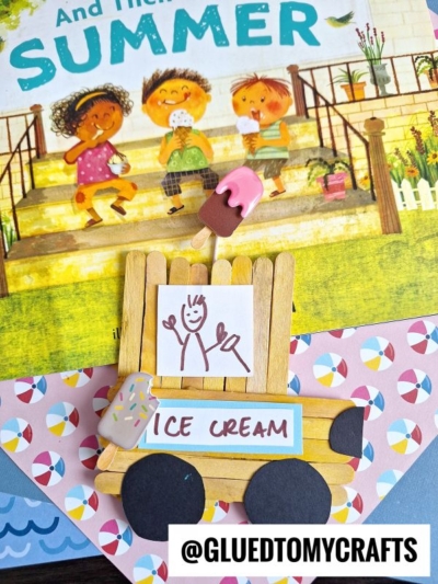 A handmade popsicle stick food truck featuring a child’s drawing and clay ice cream decorations sits on an illustrated children’s book cover showing kids eating ice cream. The handle @GLUEDTOMYCRAFTS is at the bottom.