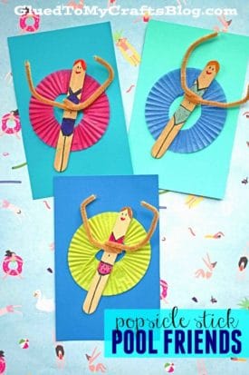 Three colorful cards display popsicle stick pool lounging friends in swimsuits with smiling faces, pipe cleaner arms, and cupcake liner floats, creating a fun craft theme.