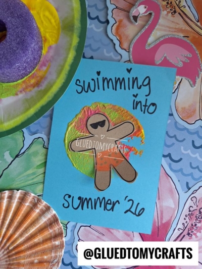 A handmade card features a paper cutout person on a painted circle, with text reading swimming into summer 26. Inspired by pool noodle crafts, the beach-themed card has a flamingo, shell, pool float, and @GLUEDTOMYCRAFTS label below.