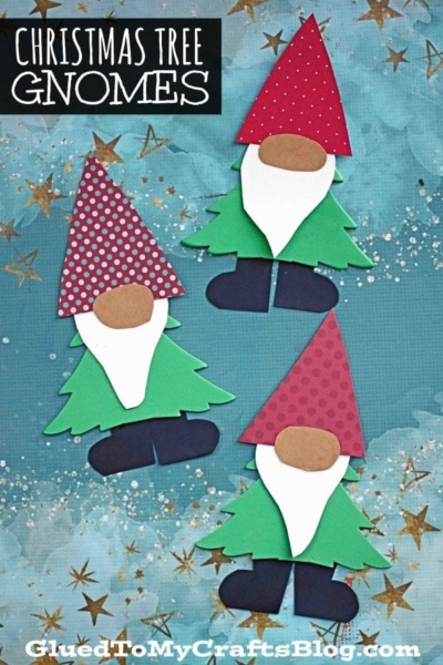Three paper christmas gnome crafts with red hats, white beards, and green tree-shaped bodies are arranged on a blue background with gold stars. Text says Christmas Tree Gnomes.