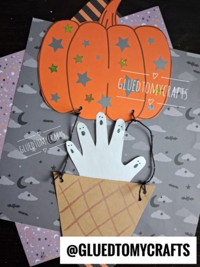 A paper craft features a jack-o-lantern hot air balloon, hand-shaped ghosts in a cone, and Halloween-themed backgrounds with stars and moons. Text overlays say GLUEDTOMYCRAFTS and @GLUEDTOMYCRAFTS.