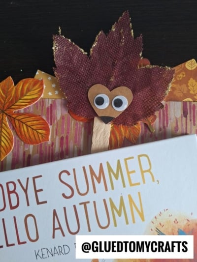 A craft leaf hedgehog character with googly eyes and a heart-shaped face peeks over a book titled “Goodbye Summer, Hello Autumn.” The username @GLUEDTOMYCRAFTS is displayed at the bottom.
