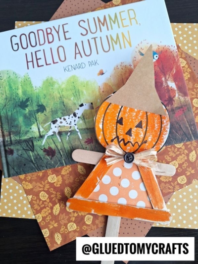 A children’s book titled “Goodbye Summer, Hello Autumn” is displayed with autumn-themed paper and a handmade pumpkin scarecrow in an orange polka-dot dress. The handle @GLUEDTOMYCRAFTS appears at the bottom.