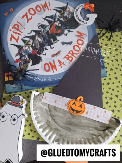 Children’s Halloween crafts: a fun paper plate witch hat paired with a pumpkin, a ghost cutout, and a book titled *Zip! Zoom! On a Broom!* There are also plastic spiders for extra spookiness and the handle @GLUEDTOMYCRAFTS shown.