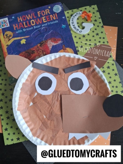 A paper plate werewolf craft with brown and white paper pieces sits on star-patterned paper, next to the book Howl for Halloween! with Brown Bear and Friends. @GLUEDTOMYCRAFTS is written at the bottom.
