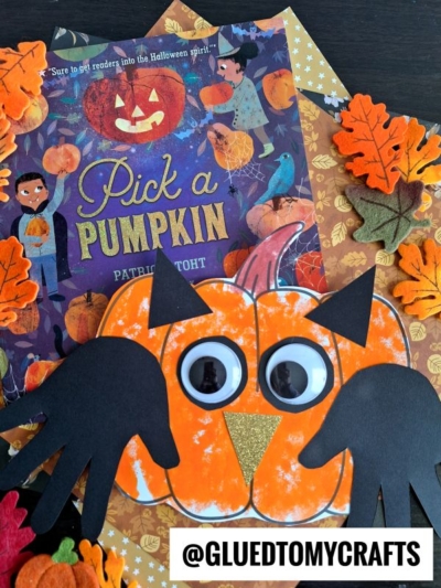 A children’s book titled Pick a Pumpkin is surrounded by autumn leaves and a pumpkin owl craft with googly eyes and black paper wings. The Instagram handle @GLUEDTOMYCRAFTS appears at the bottom.