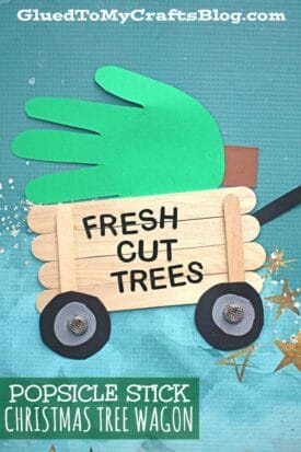 A popsicle stick Christmas tree wagon holds a green handprint "tree" with FRESH CUT TREES on the side, making a festive DIY popsicle stick Christmas tree wagon craft.