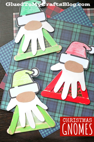 Three handmade Craft Stick Christmas Gnomes made with paper, popsicle sticks, and handprint cutouts are displayed on plaid paper backgrounds with the words CHRISTMAS GNOMES in the corner.