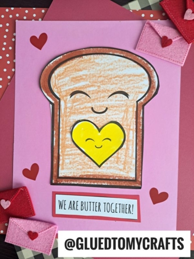 This Punny Toast Card features a smiling slice of bread with a yellow heart-shaped pat of butter, red hearts, felt envelopes, and the playful phrase "We are butter together!" at the bottom.