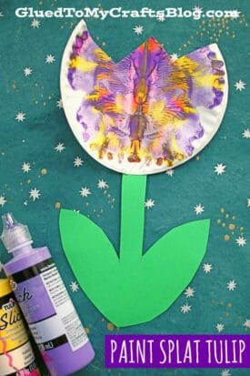 A vibrant paint splat tulip, crafted from a painted coffee filter, features green paper stems and leaves on a teal background with white dots. Paint bottles sit nearby. Text: PAINT SPLAT FLOWER.