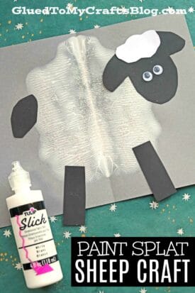An art project features a paint splat sheep made with white paint for the body, black paper for the head and legs, and white paper on top. A bottle of paint is nearby. Text reads, Paint Splat Sheep Craft—a fun sheep craft for kids.
