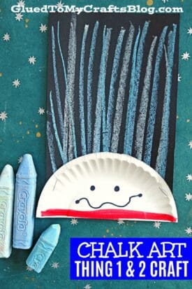 A fun kids’ craft featuring chalk art Thing 1 lines for hair, a half paper plate face, and chunky crayons on a starry green background. Text reads “CHALK ART THING 1 & 2 CRAFT.”.