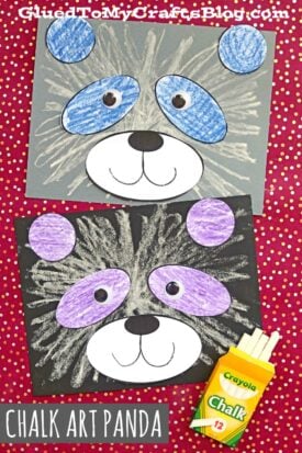 Two panda faces drawn on black and gray paper using chalk and colored pencils—one blue, one purple—on a red polka dot background. A Crayola chalk box sits in the corner. Text reads CHALK ART PANDA, a fun panda craft for kids.