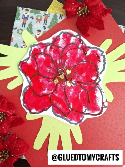 A handmade craft featuring a Handprint Poinsettia Flower with red petals and gold glitter accents on a white background, layered over green paper hand shapes and festive red patterned paper, with poinsettia decorations and holiday-themed backgrounds.