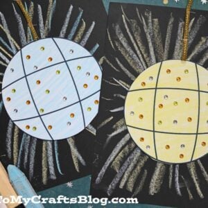Two chalk art disco ball crafts on black paper, one blue and one yellow, are decorated with sequins and crayon lines radiating outward. Three pastel sticks are nearby, and GluedToMyCraftsBlog.com appears at the bottom.