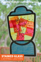 A stained glass camping lantern craft made with colorful tissue paper squares and star-shaped confetti, displayed on a window. The text reads GluedToMyCraftsBlog.com and Stained Glass Paper Camping Lantern.