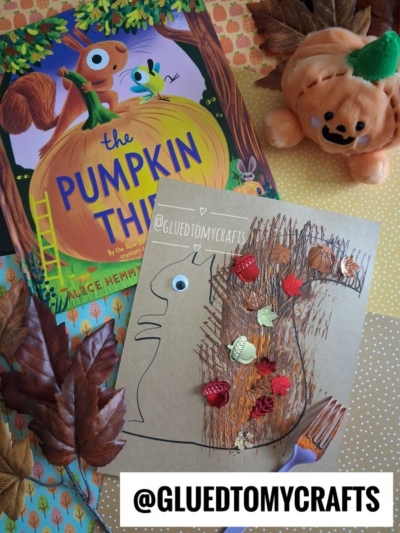 Children’s pumpkin book, a pumpkin plush, autumn leaves, and a fork painted squirrel craft made with brown paint and plastic leaves on brown paper. The handle @GLUEDTOMYCRAFTS is at the bottom of the image.