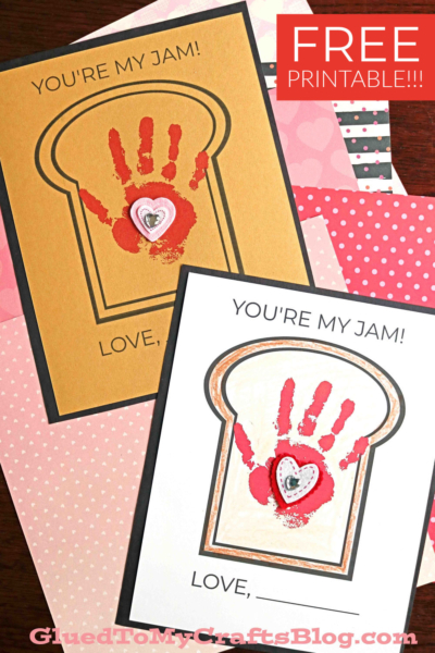 Two handmade "you're my jam" cards shaped like bread slices feature red handprints and hearts, with YOURE MY JAM! above and LOVE below. The image also offers a free printable on pink patterned paper backgrounds.