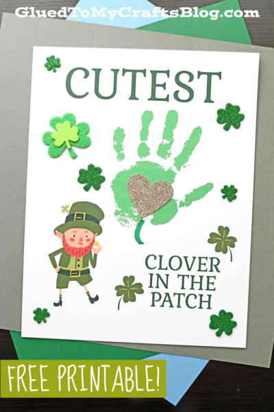 A St. Patrick’s Day craft page featuring a green handprint clover, glittery gold heart, cartoon leprechaun, and shamrocks. The text reads, “CUTEST CLOVER IN THE PATCH.” The bottom labels it as a free printable.