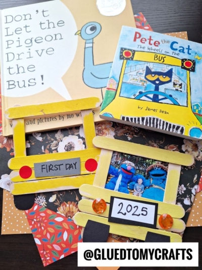 Two children’s books about buses and two yellow school bus frame crafts made from craft sticks are arranged on a patterned surface. One craft displays FIRST DAY, the other shows 2025 with a photo. @GLUEDTOMYCRAFTS is at the bottom.