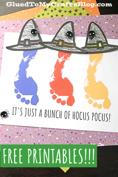 A Halloween-themed craft showcases footprint Sanderson sisters in purple, orange, and yellow, each with a witch hat and googly eyes. Text reads “It’s just a bunch of hocus pocus!” plus “FREE PRINTABLES!!!” – a perfect hocus pocus keepsake!.