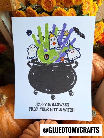 Halloween craft with green and purple handprints above a black cauldron, surrounded by cartoon ghosts, a bat, and stars. This adorable handprint Halloween cauldron makes the perfect little witch keepsake! Text below reads: HAPPY HALLOWEEN FROM YOUR LITTLE WITCH!.