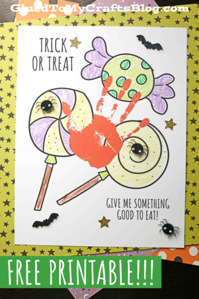 A Halloween-themed printable features a spooky handprint trick or treat design with two colored lollipops, spiders, bats, stars, and an orange monster handprint. Text reads Trick or Treat and Give me something good to eat! Free printable!.