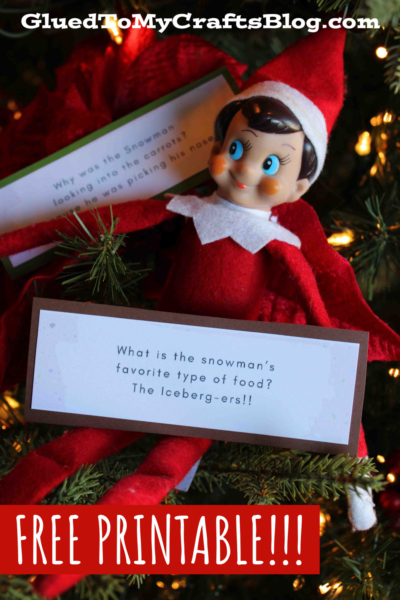 An Elf on the Shelf doll sits in a Christmas tree holding Christmas jokes for kids cards. The text reads “GluedToMyCraftsBlog.com” at the top and “FREE PRINTABLE!!!” at the bottom in bold red and white letters.