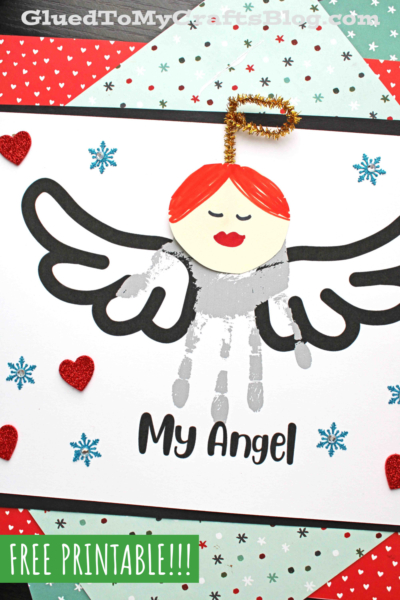 Handmade handprint angel craft on paper, featuring a child's gray handprint as the angel’s body, black marker wings, a round face with red hair, and a gold pipe cleaner halo. The words My Angel are below the angel.