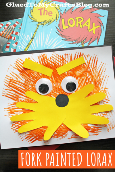 A fork painted Lorax face made from yellow paper cutouts, large googly eyes, and orange paint streaks for fur sits on paper above a copy of The Lorax book. Text reads: FORK PAINTED LORAX.