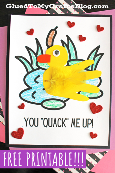 A handmade card features a cheerful handprint duck with a googly eye and orange beak, placed on a drawing of a pond with red glitter hearts. Text reads YOU QUACK ME UP! and FREE PRINTABLE!!!.