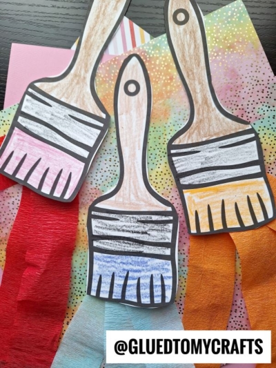 Three paper paint brush craft creations with colored handles and vibrant bristles—red, blue, and orange tips—are displayed on a multicolored dotted background. The Instagram handle @GLUEDTOMYCRAFTS is at the bottom.