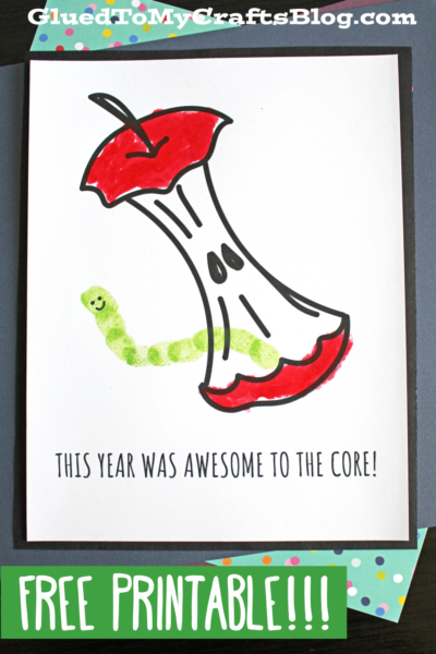 A handmade card features a cartoon apple core with a smiling fingerprint worm craft. The card reads: This year was awesome to the core! FREE PRINTABLE!!! is highlighted at the bottom.