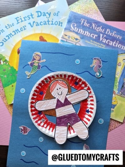 A handmade summer craft featuring pool floatie art: a paper plate with a child cutout colored like swimming in a pool, placed on blue paper with sea creature stickers, atop two summer-themed children’s books. @GLUEDTOMYCRAFTS is at the bottom.