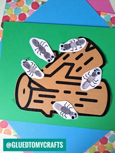 A green card features an Ants On A Log Craft—a brown paper log with five black thumbprint ants and googly eyes, arranged around the log. Colorful paper accents the background. @GLUEDTOMYCRAFTS is written at the bottom.